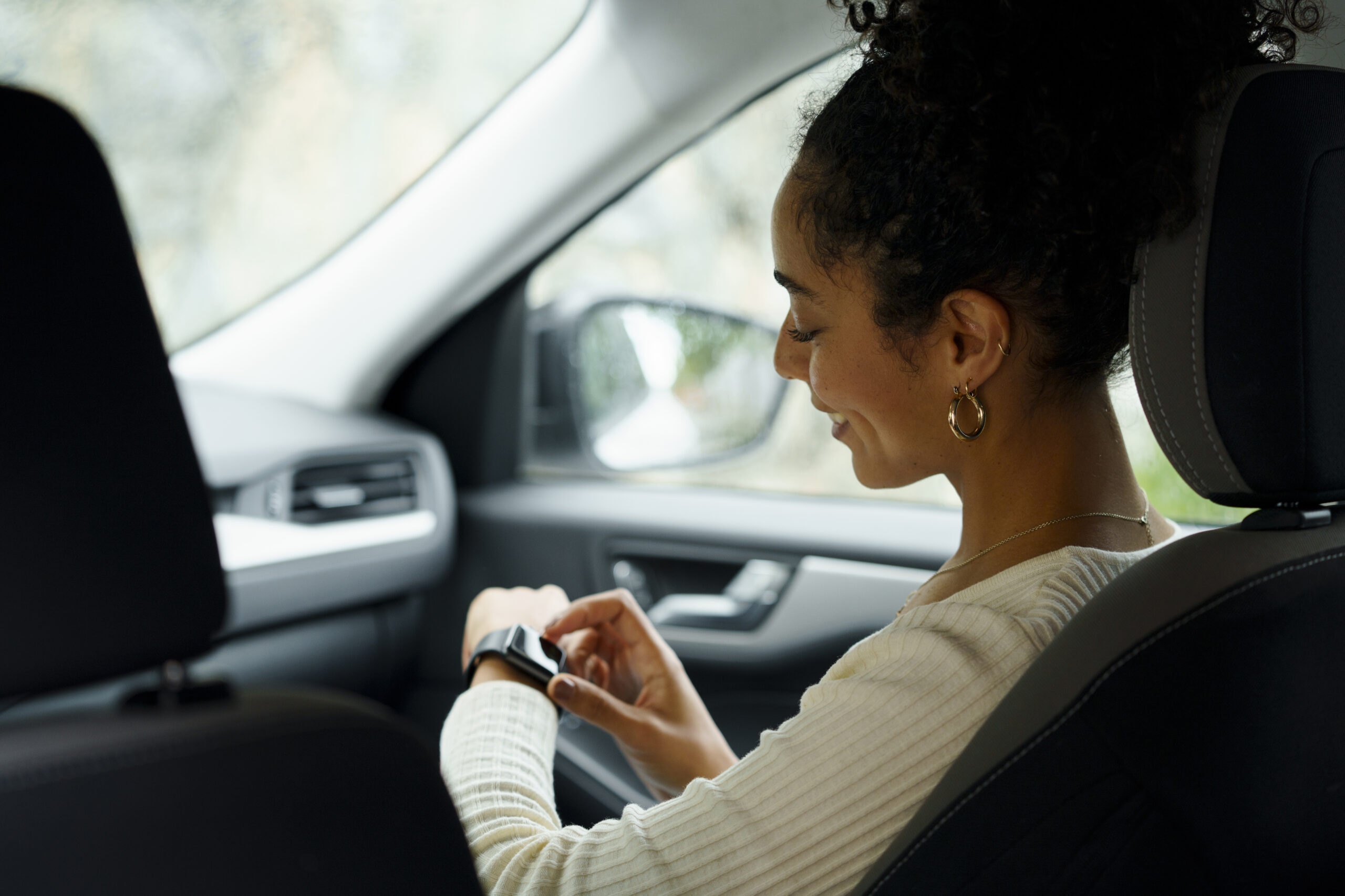 woman looking at her watch in the car
